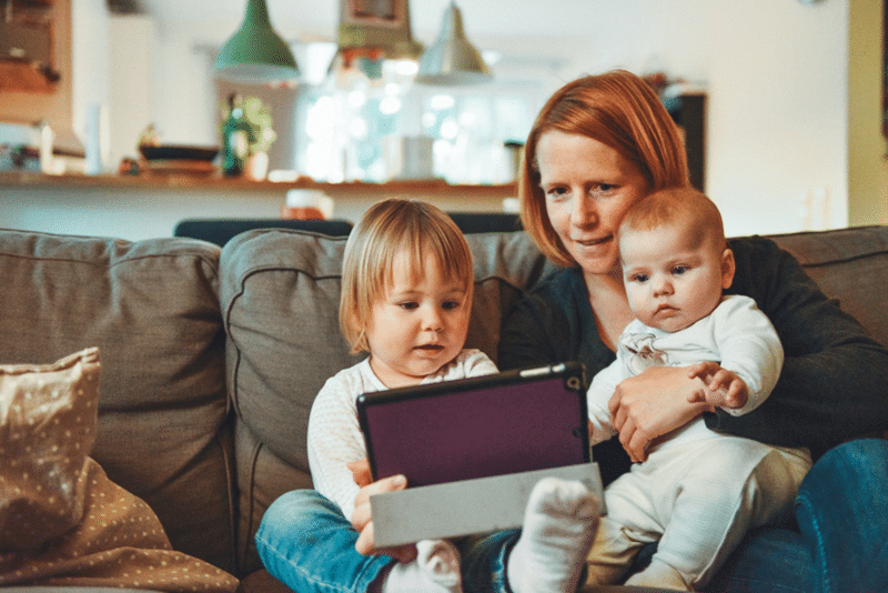 kid seeing tablet device in front of parent