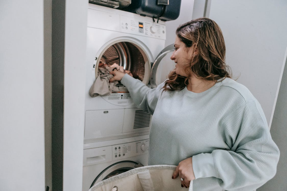 Woman inspecting laundry for safety and maintenance tips.